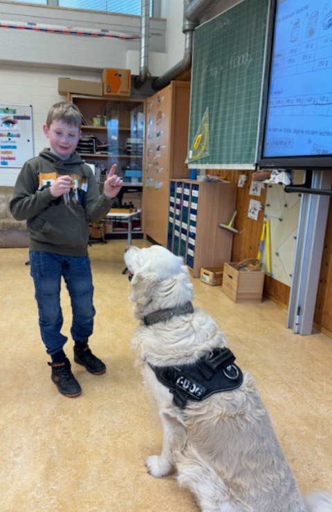 Schüler mit sitzendem Schulhund Toni